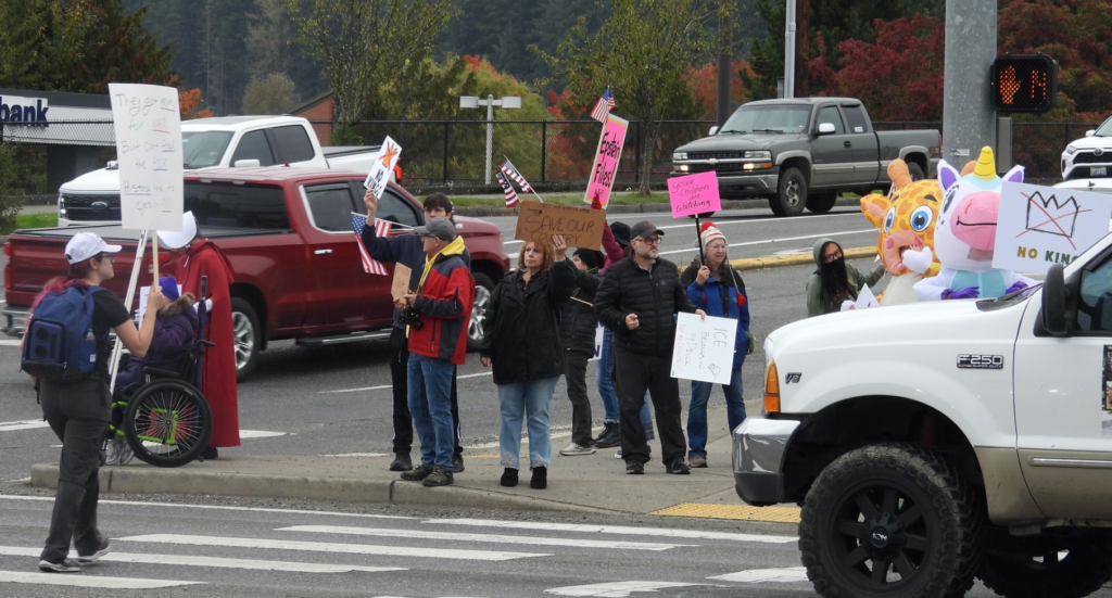 No Kings Protest, Oct 18, Monroe, WA. People with signs standing at a street corner.